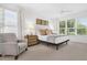 Bright bedroom with neutral tones, large windows, and a comfortable chair with a side table at 453 Treviso Dr, Poinciana, FL 34759