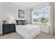 Bright bedroom with a large window, neutral walls, and a comfortable bed with decorative pillows at 453 Treviso Dr, Poinciana, FL 34759