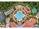 Aerial view of a community pool with lounge chairs, lush greenery, and tennis courts at 453 Treviso Dr, Poinciana, FL 34759