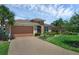 Beautiful home featuring a paver driveway, lush landscaping, and a well-manicured lawn at 453 Treviso Dr, Poinciana, FL 34759