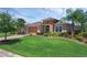 Well-maintained home with a lush green lawn, colorful landscaping, and a brick paver driveway at 453 Treviso Dr, Poinciana, FL 34759