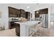 A stylish kitchen featuring a large island with bar seating, dark cabinetry, and modern appliances at 453 Treviso Dr, Poinciana, FL 34759