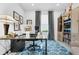 Bright office features a glass desk, patterned rug, and built-in shelving with decor at 453 Treviso Dr, Poinciana, FL 34759