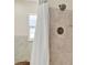 Cozy bathroom featuring stone-look tile and a window, providing a relaxing space at 1007 N Shore Dr, Leesburg, FL 34748