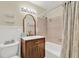 Stylish bathroom with wood vanity, modern fixtures, and bathtub with tiled shower at 1007 N Shore Dr, Leesburg, FL 34748