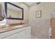Bright bathroom featuring a vanity with granite countertop and a decorative mirror at 1007 N Shore Dr, Leesburg, FL 34748