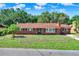 Well-maintained single-story home with a brick facade and mature trees at 1007 N Shore Dr, Leesburg, FL 34748