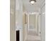 A bright hallway featuring neutral walls and flooring, with a view of other rooms in the house at 1007 N Shore Dr, Leesburg, FL 34748