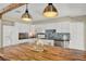An open kitchen featuring white cabinets, stainless steel appliances, a tile backsplash and a butcher block island at 1007 N Shore Dr, Leesburg, FL 34748