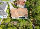 Aerial view of luxury home with clay tile roof, private pool, and wooded backyard at 10122 Royal Island Ct, Orlando, FL 32836