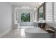 Bright bathroom featuring large walk-in shower, tub, double vanity, and shutters at 10122 Royal Island Ct, Orlando, FL 32836