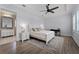Bright bedroom with a ceiling fan, tray ceiling, a desk, and an ensuite bathroom featuring modern fixtures at 10122 Royal Island Ct, Orlando, FL 32836
