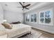 Bright bedroom featuring a tray ceiling, ceiling fan, plantation shutters, and wood-look flooring for a modern look at 10122 Royal Island Ct, Orlando, FL 32836
