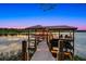 Private boat dock with covered seating offers relaxation and recreational opportunities on the serene waterfront at 10122 Royal Island Ct, Orlando, FL 32836