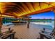 Picturesque waterfront dock featuring a boat lift, underlit roof, and comfortable seating, ideal for enjoying serene sunsets on the water at 10122 Royal Island Ct, Orlando, FL 32836