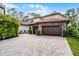 Stately home featuring stone accents, a tile roof, and a spacious driveway with a three-car garage at 10122 Royal Island Ct, Orlando, FL 32836