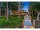 Gorgeous waterfront property features a lighted wooden walkway through the mature trees, creating a peaceful entry to an elegant home at 10122 Royal Island Ct, Orlando, FL 32836