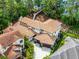 Aerial view of a luxurious house showcasing a tile roof, paver driveway, and lush landscaping at 10122 Royal Island Ct, Orlando, FL 32836