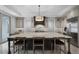 Well-appointed kitchen featuring an oversized island with counter seating, a designer pendant light, and a stainless fridge at 10122 Royal Island Ct, Orlando, FL 32836