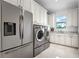 Spacious laundry room with modern washer, dryer, refrigerator and plenty of cabinet storage space at 10122 Royal Island Ct, Orlando, FL 32836