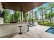 Elegant outdoor space with a custom bar, seating, and partial view of pool and dock, great for entertaining outdoors at 10122 Royal Island Ct, Orlando, FL 32836