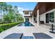 Luxury home featuring a plunge pool with a fountain, covered patio, and manicured landscaping, creating a serene outdoor oasis at 10122 Royal Island Ct, Orlando, FL 32836