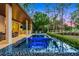Tranquil pool, waterfront property with an outdoor kitchen and multiple seating areas for entertaining at 10122 Royal Island Ct, Orlando, FL 32836
