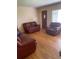 Comfortable living room with hardwood floors, leather seating, and bright window at 1022 E 3Rd Ave, Mount Dora, FL 32757
