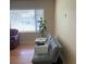 Cozy living room featuring a comfortable gray couch and large window at 1022 E 3Rd Ave, Mount Dora, FL 32757