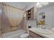 This bathroom features neutral tile, a vanity with decor, toilet, and bathtub with decorative shower curtain at 11287 Stewart Loop, Oxford, FL 34484