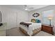 This bedroom features a neutral color palette, window with blinds, and decorative mirror above the bed at 11287 Stewart Loop, Oxford, FL 34484