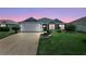 Charming single-story home with a well-manicured lawn and an attached two-car garage at 11287 Stewart Loop, Oxford, FL 34484