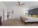 Well-lit bedroom featuring a large bed, ceiling fan, and an open doorway to other parts of the home at 11287 Stewart Loop, Oxford, FL 34484