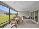 This screened patio includes a dining table and chairs, ceiling fans, and views of the backyard at 11287 Stewart Loop, Oxford, FL 34484