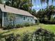 Charming home with blue siding, well-maintained landscaping, mature trees and a neatly manicured lawn at 1225 E 1St Ave, Mount Dora, FL 32757