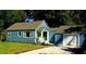 Charming blue home featuring a well-manicured front yard and a one-car garage at 1225 E 1St Ave, Mount Dora, FL 32757
