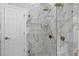 Bathroom with glass shower, marble walls, and gold hardware at 12833 Hyland Ln, Clermont, FL 34711