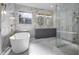 Luxurious bathroom with freestanding tub, glass shower, and marble finishes at 12833 Hyland Ln, Clermont, FL 34711