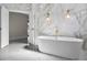 Elegant bathroom features a freestanding tub, marble walls, and gold fixtures at 12833 Hyland Ln, Clermont, FL 34711