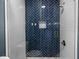 Modern walk-in shower with blue herringbone tile and glass door at 12833 Hyland Ln, Clermont, FL 34711