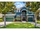 Charming two-story house featuring a lush front yard, mature trees, and a welcoming entrance at 12833 Hyland Ln, Clermont, FL 34711
