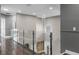 Hallway with hardwood floors, glass railing, and decorative chandelier at 12833 Hyland Ln, Clermont, FL 34711