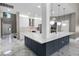Bright, open kitchen featuring a large island, white cabinets, stainless steel appliances, and marble flooring at 12833 Hyland Ln, Clermont, FL 34711