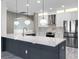 Stylish kitchen with a large island, stainless steel appliances, white cabinets, and modern pendant lighting at 12833 Hyland Ln, Clermont, FL 34711