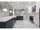 Open kitchen with an island, stainless steel appliances, white cabinets, and elegant marble flooring at 12833 Hyland Ln, Clermont, FL 34711