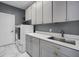 Laundry room with modern cabinetry, stainless steel sink, and a washer and dryer at 12833 Hyland Ln, Clermont, FL 34711