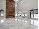 Open-concept living room with a modern fireplace, large windows, and marble flooring at 12833 Hyland Ln, Clermont, FL 34711
