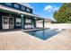 Inviting backyard pool with covered patio and stylish outdoor furniture at 12833 Hyland Ln, Clermont, FL 34711