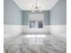 Bright, airy room with wainscoting, contemporary lighting, and white marble flooring at 12833 Hyland Ln, Clermont, FL 34711
