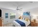 Cozy bedroom with ceiling fan, large window, and decorative blue accents at 1291 Jonesville Ter, The Villages, FL 32162